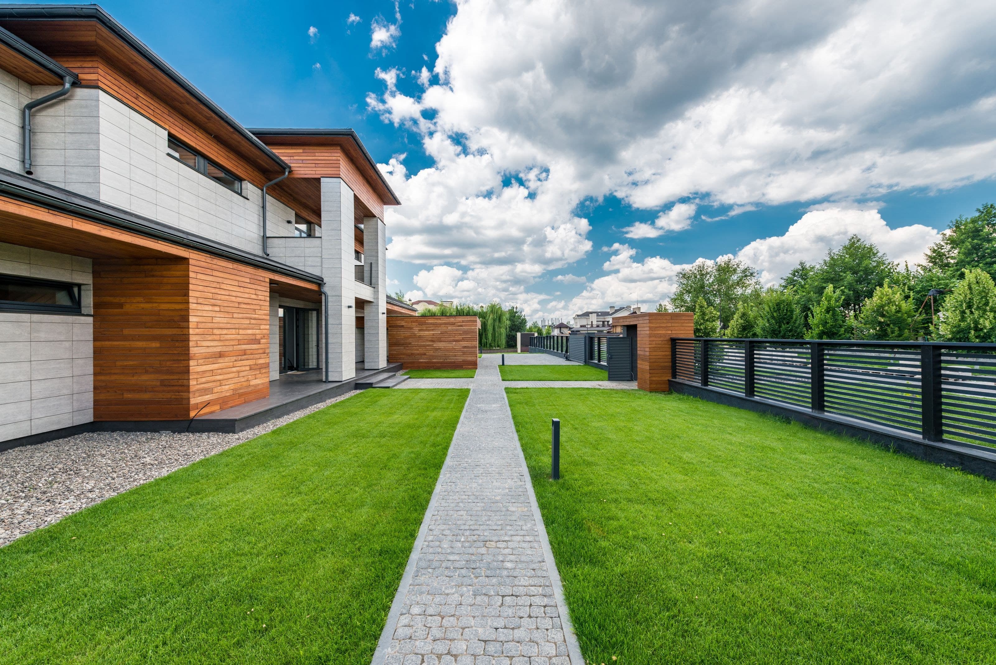 Modernes Wohnhaus mit gepflegtem Rasen und gepflastertem Weg